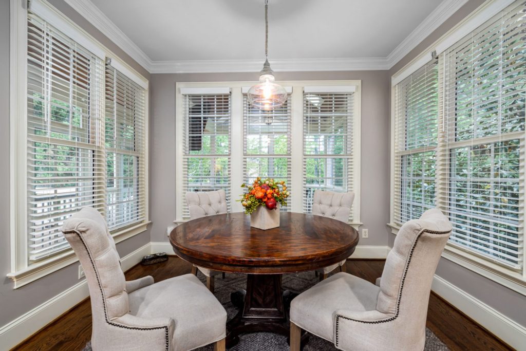 Bright dining room with classic decor featuring a round table and floral centerpiece.