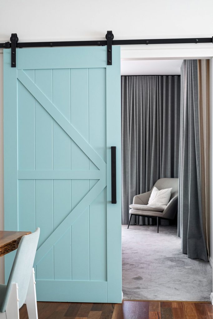 Contemporary room with a sliding barn door and cozy armchair.