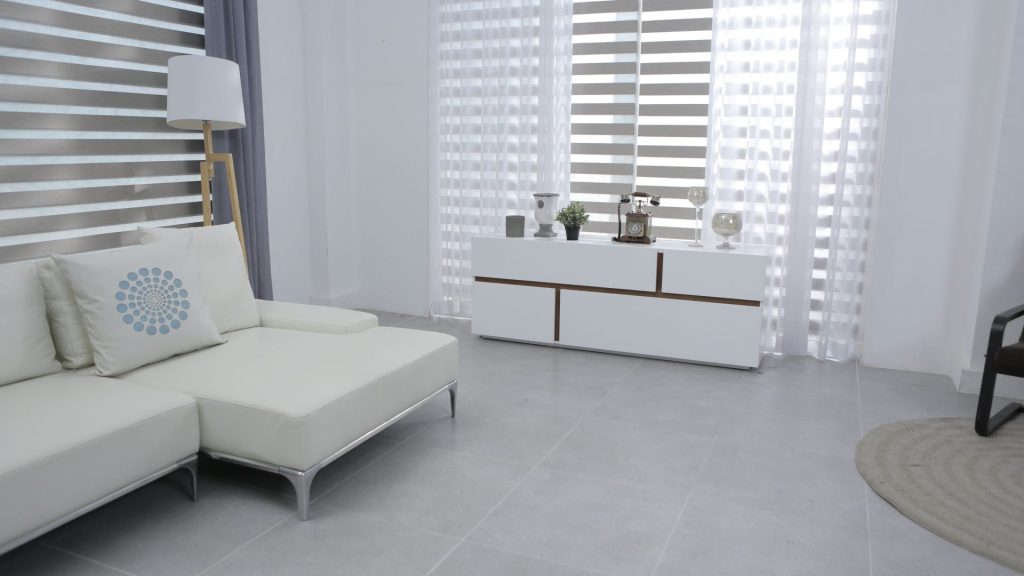 Bright and spacious living room featuring modern minimalist decor, a white sofa, and sleek furniture.