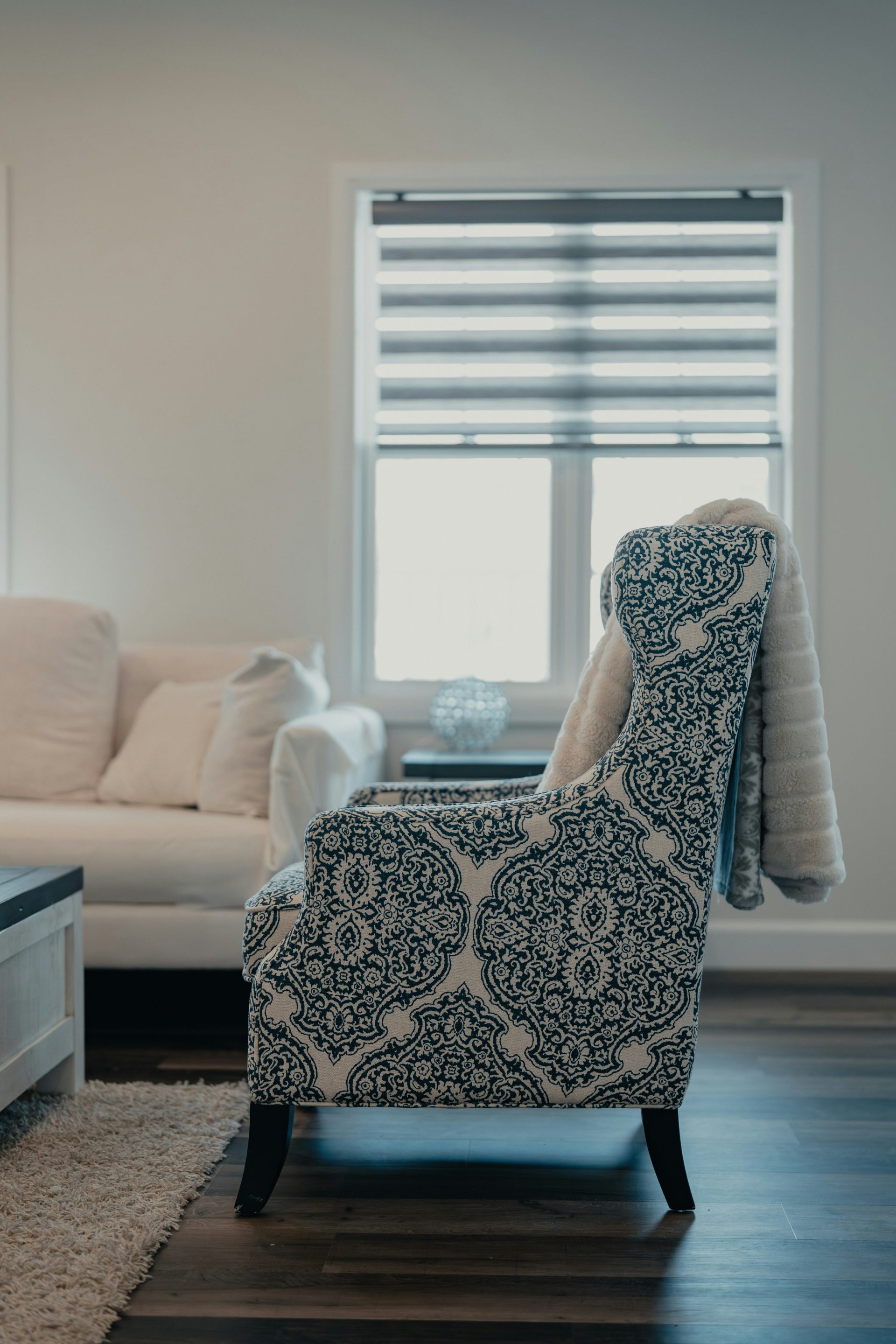Patterned armchair with blanket near window
